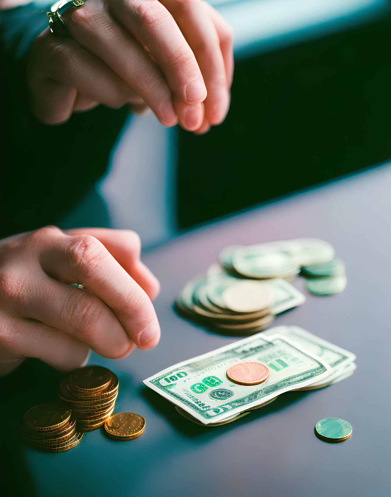 Hands Sorting Coins and Bills on Table