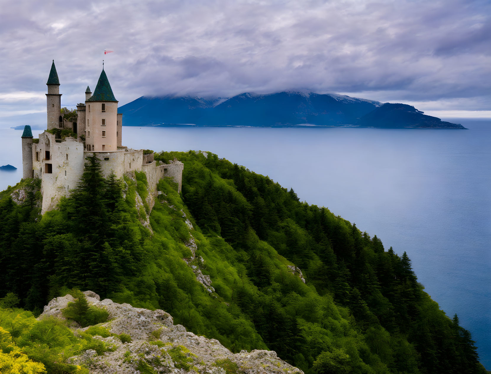 Medieval castle with turrets on cliff by blue sea