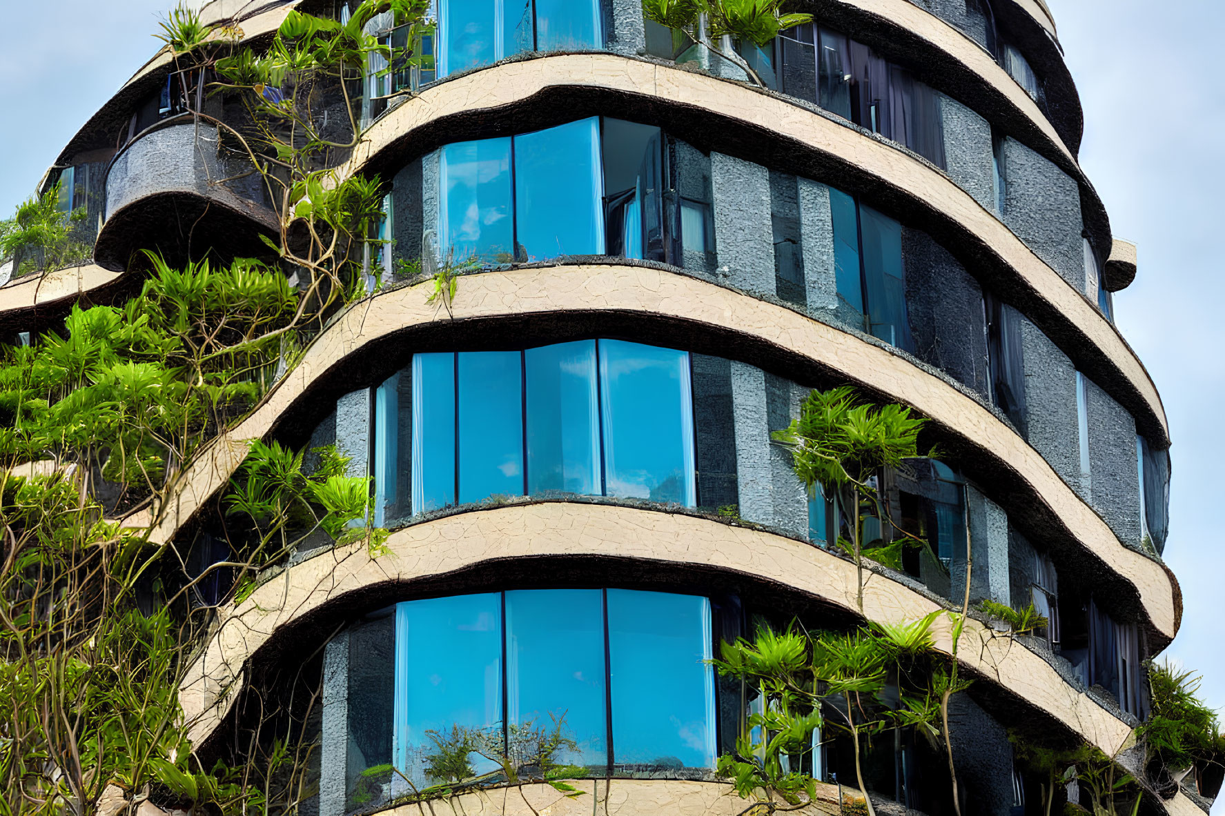 Contemporary building with green plant-lined balconies and reflective glass windows under blue skies.