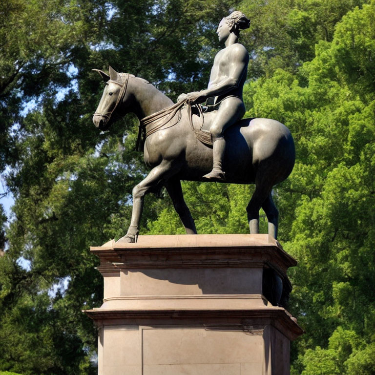 Bare-chested male rider statue on horse with trees in background