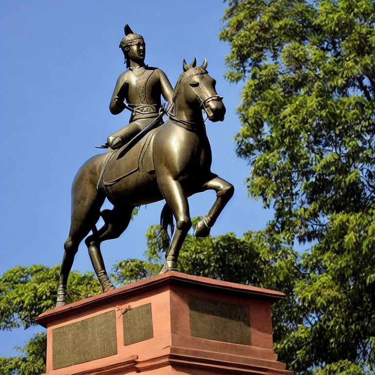 Historical figure on horseback bronze statue outdoors against blue sky.