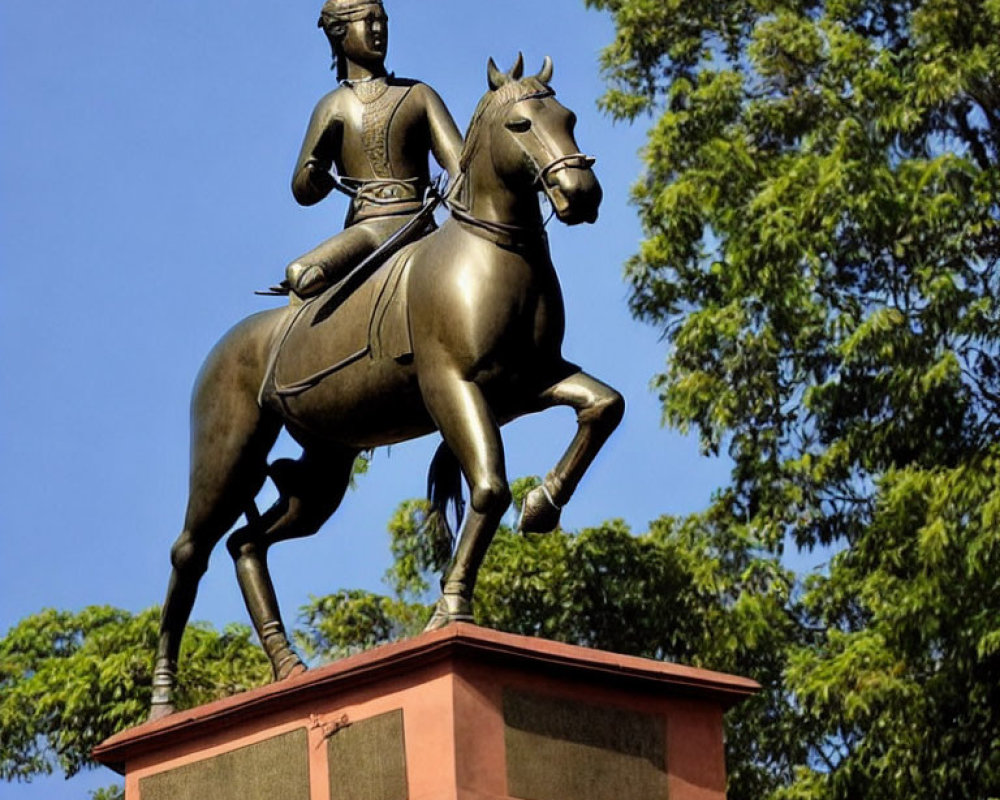 Historical figure on horseback bronze statue outdoors against blue sky.