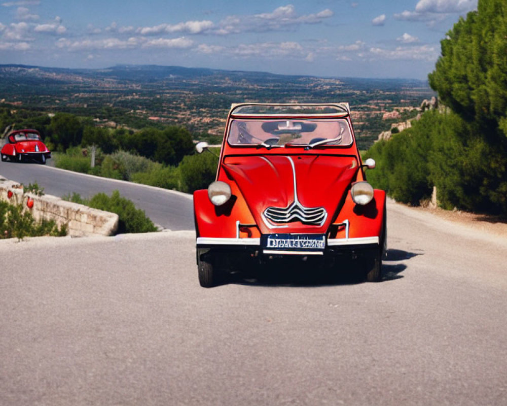 Vintage Red Car Drives on Scenic Road Amid Hilly Landscape