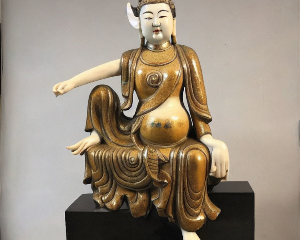 Serene Asian-inspired statue in flowing robes, seated gracefully.