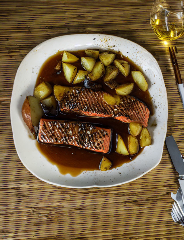 Salmon Fillets and Roasted Potatoes on White Plate with Sauce, Wooden Table Setting