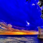 Tranquil Beach Sunrise with Radiant Sky and Silhouetted Foliage