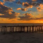 Tranquil sunset seascape with wooden pier and birds