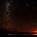 Starry Night Sky Transitions to Sunset Over Mountain Landscape