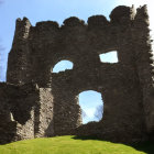 Ancient stone building ruins with large arched windows on clear blue sky