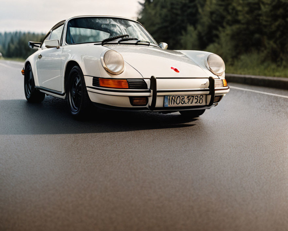 Classic White Porsche Car with Red Stripe Driving on Forested Asphalt Road