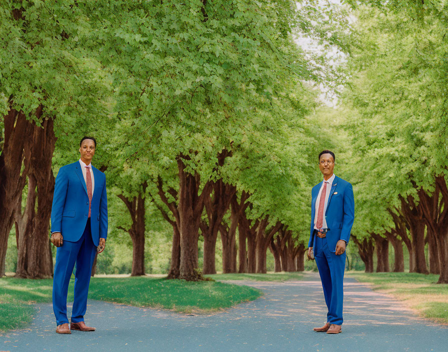 Two Men in Blue Suits on Tree-Lined Path