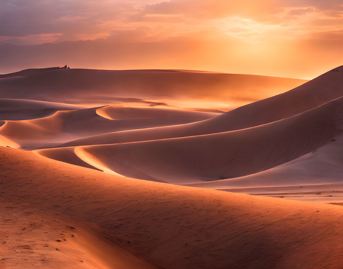 Tranquil desert sunset with person on distant ridge