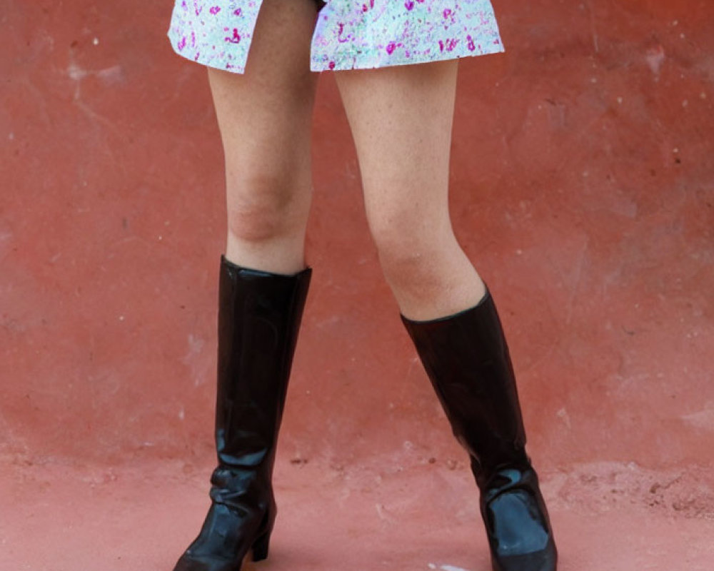 Floral skirt and tall boots on red surface with broken red object pieces