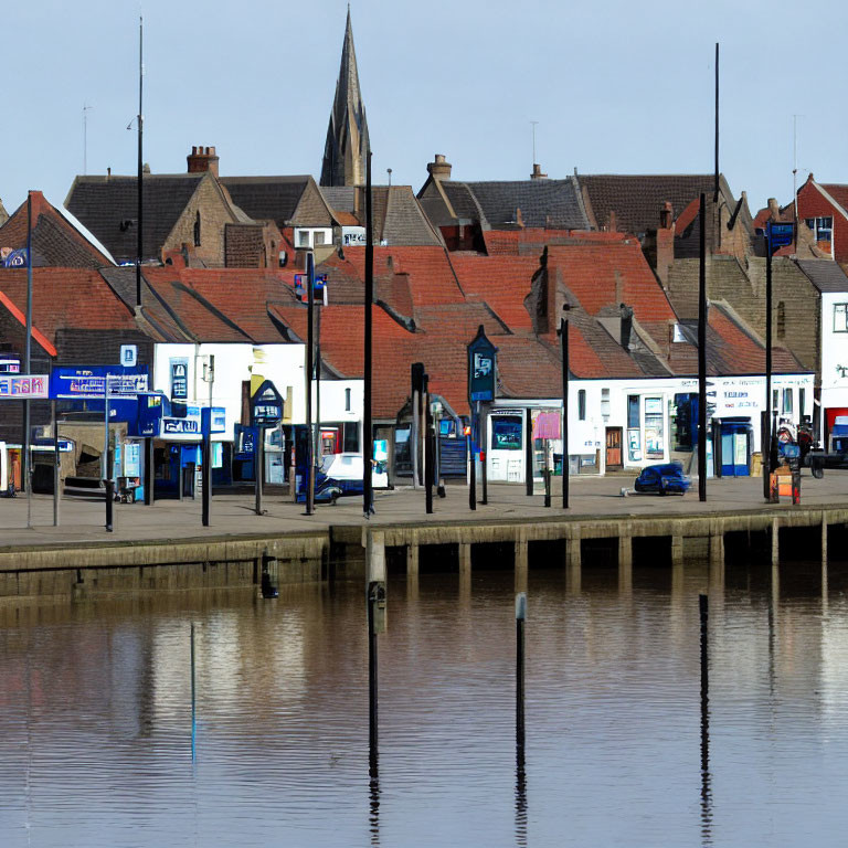 Charming waterfront town with shops, church spire, and calm water