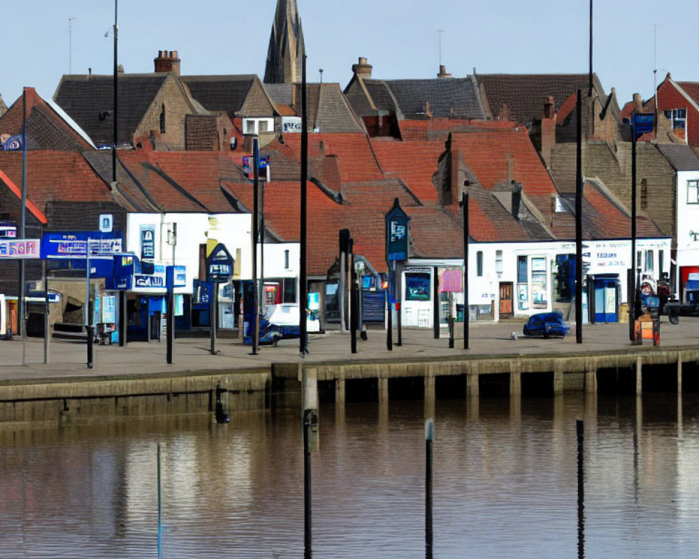 Charming waterfront town with shops, church spire, and calm water