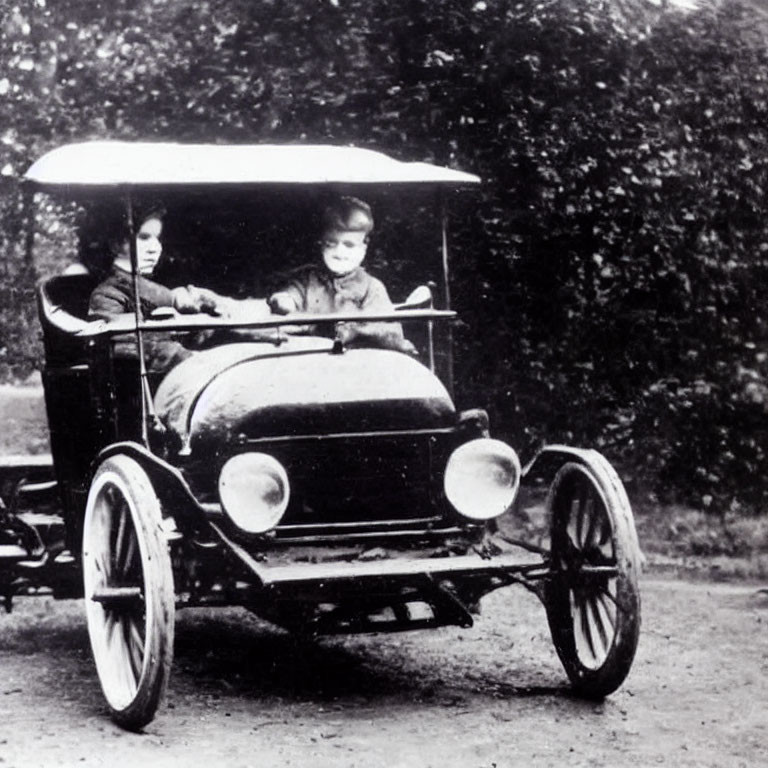 Vintage open automobile with round headlights on dirt road