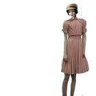 Abstract-patterned dresses and stylish hats on mannequins.