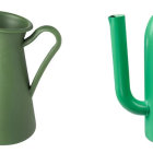 Four colorful ceramic pitchers with varied designs and handles on white background.