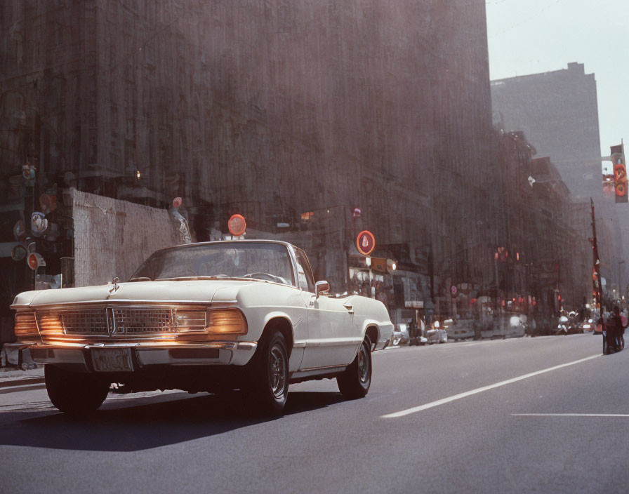 Vintage White Car Driving in Urban Setting with Pedestrians and Traffic Lights