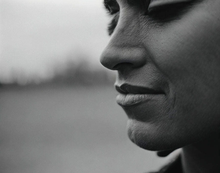 Monochrome close-up side profile of smiling person