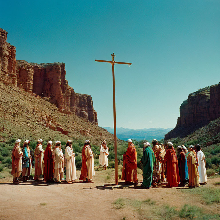 Group of People in Biblical Attire Around Cross in Desert Canyon