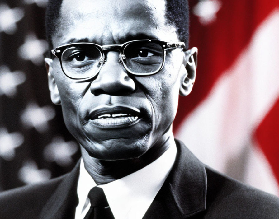 Man in suit and glasses against American flag background