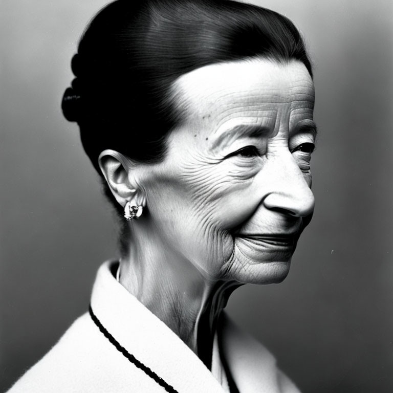 Elderly woman with bun hair and earrings in monochrome portrait