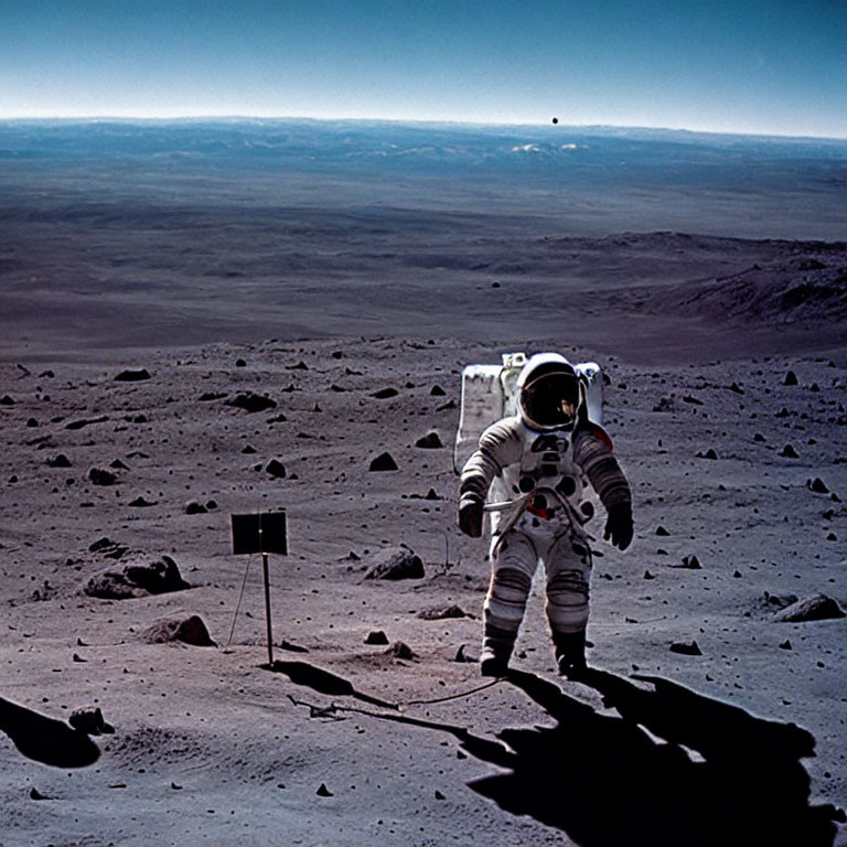 Astronaut in white space suit on lunar surface with Earth in sky