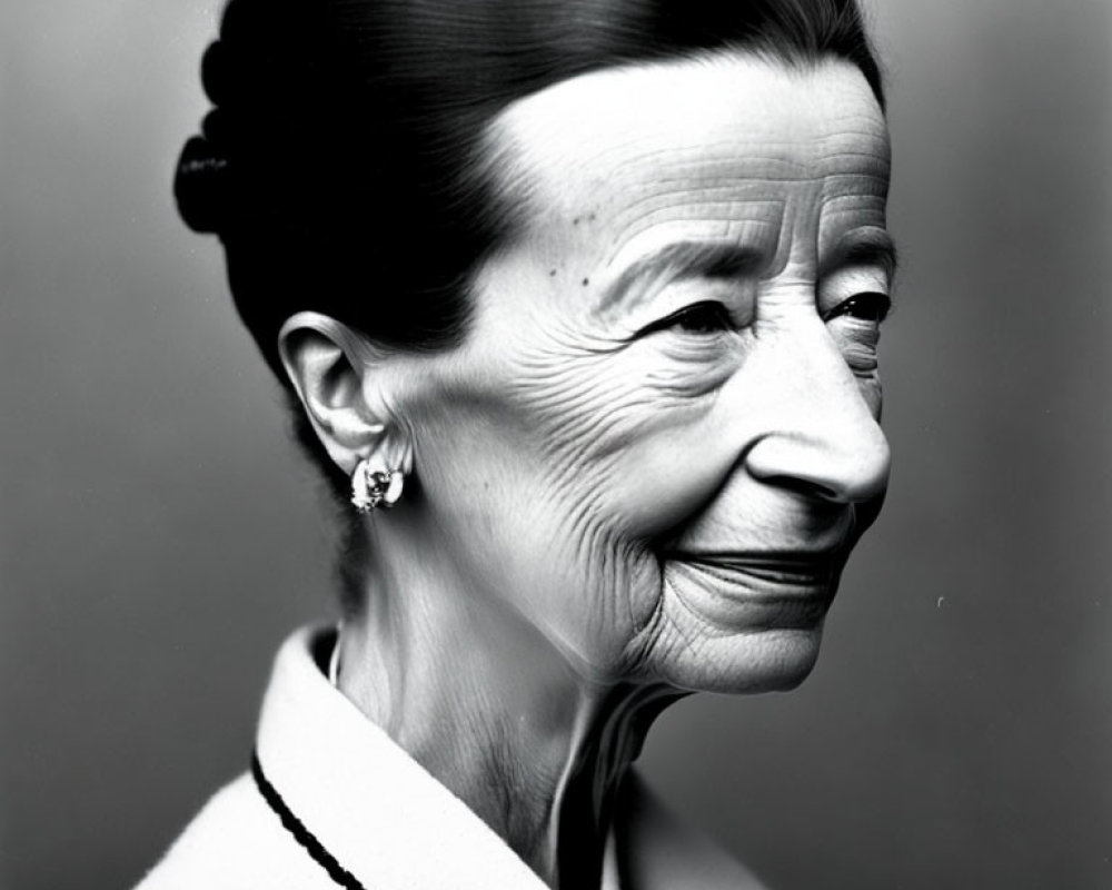 Elderly woman with bun hair and earrings in monochrome portrait