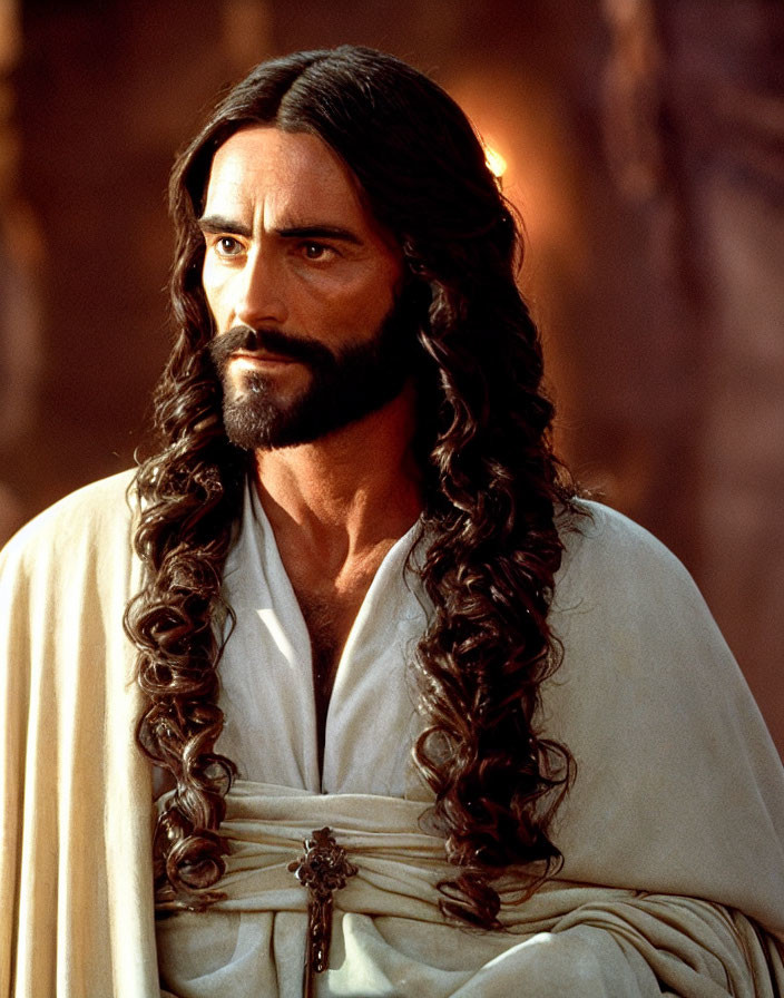 Bearded man in white robe with crucifix pendant gazes intently