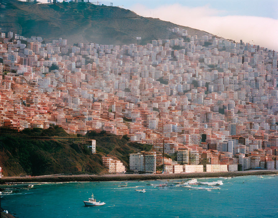 Uniform Reddish-Brown Buildings on Hillside Overlooking Bay with Sailing Boats