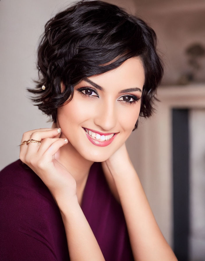 Smiling woman in plum dress with short dark hair