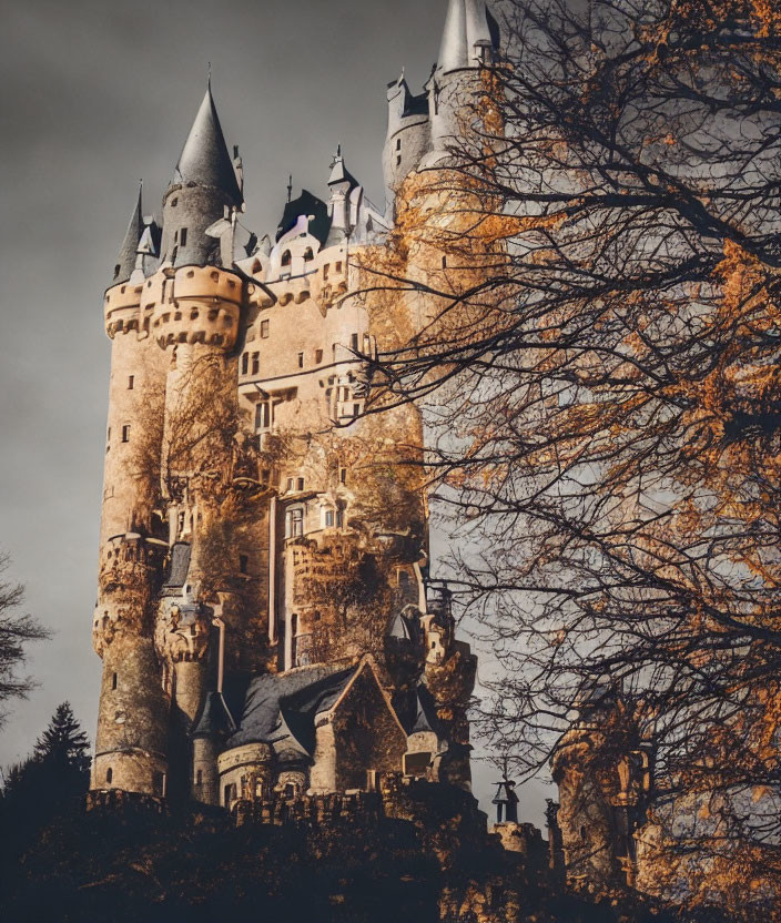 Majestic fairytale castle with spires and autumn foliage against dramatic sky