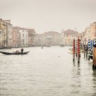 European-style harbor scene with sailboats, calm waters, duck, and distant mountains.