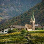 Enchanted cottage, spires, stone bridge, cloaked figure in fantasy landscape