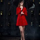 Woman in Red and Black Outfit Against Intricate Decorative Background