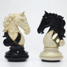 Ornate black and white chess knight pieces with golden embellishments