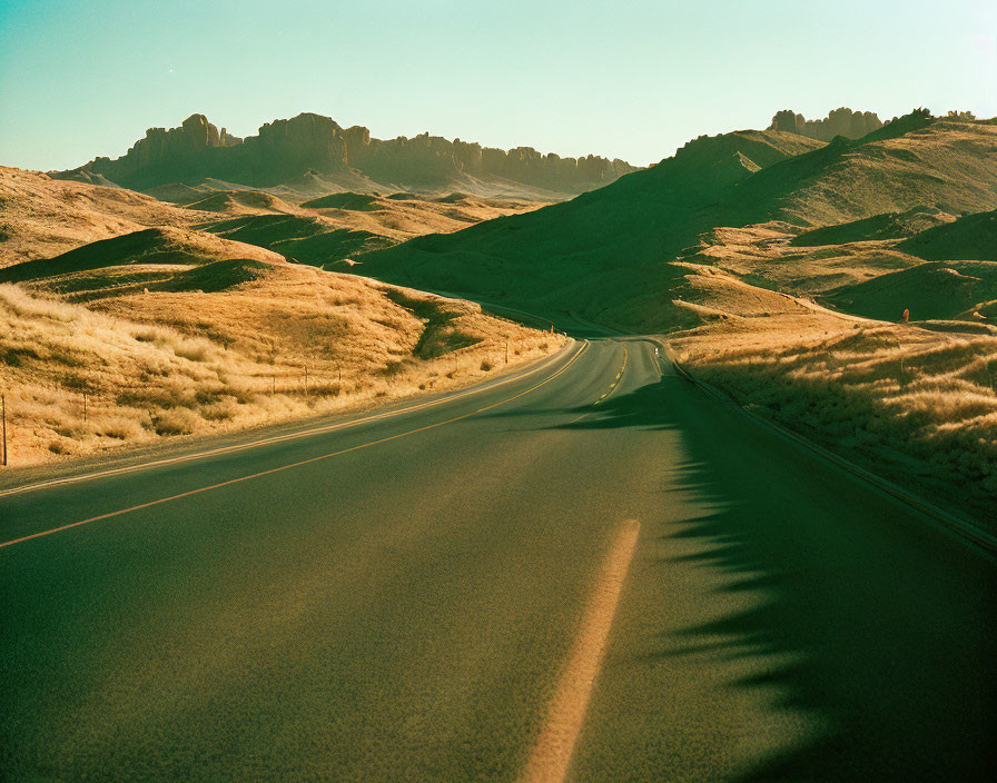 Winding Road Through Hilly Grass Landscape