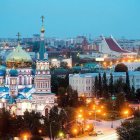 Traditional Russian town with ornate churches, golden domes, and ferris wheel in snowy evening scene