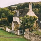 Ivy-covered cottage in lush greenery with rolling hills