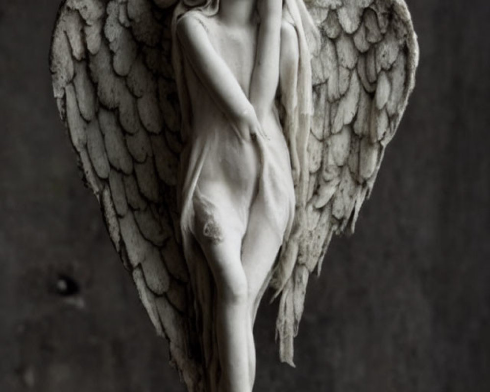 Detailed Angel Sculpture with Feathered Wings on Pedestal in Sorrowful Pose