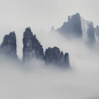 Ethereal landscape of misty mountain peaks and trees emerging from clouds