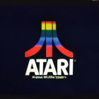 Colorful Illuminated Atari Logo on Dark Blue Background with Torn Surface