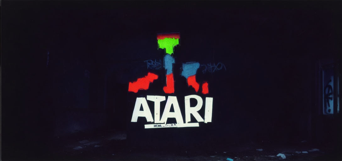 White "Atari" logo graffiti on dark background with colorful paint splashes and bright window.