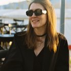 Blonde woman in sunglasses and blazer under dramatic lighting