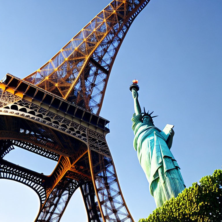 Iconic landmarks under clear blue sky: Eiffel Tower and Statue of Liberty replica.