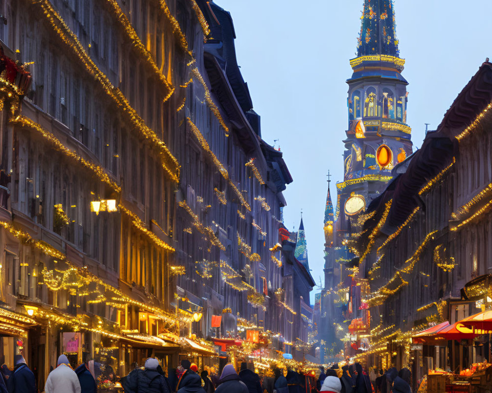 City street scene at dusk with illuminated clock tower & string lights