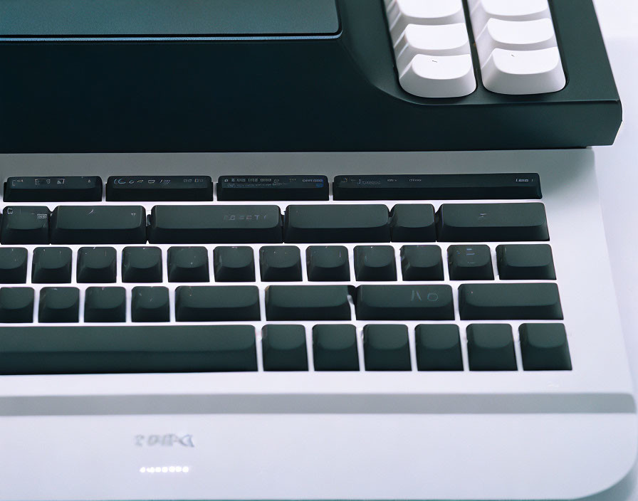 Dark key mechanical keyboard on white desk with monitor in background