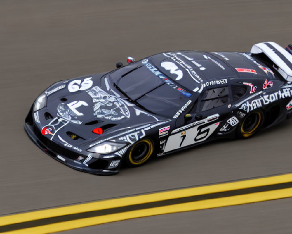 Black and Grey Racing Car with Number 16 and Sponsor Logos on Racetrack