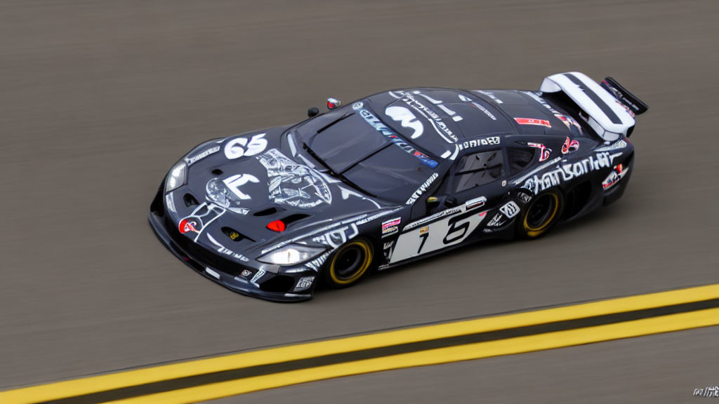 Black and Grey Racing Car with Number 16 and Sponsor Logos on Racetrack